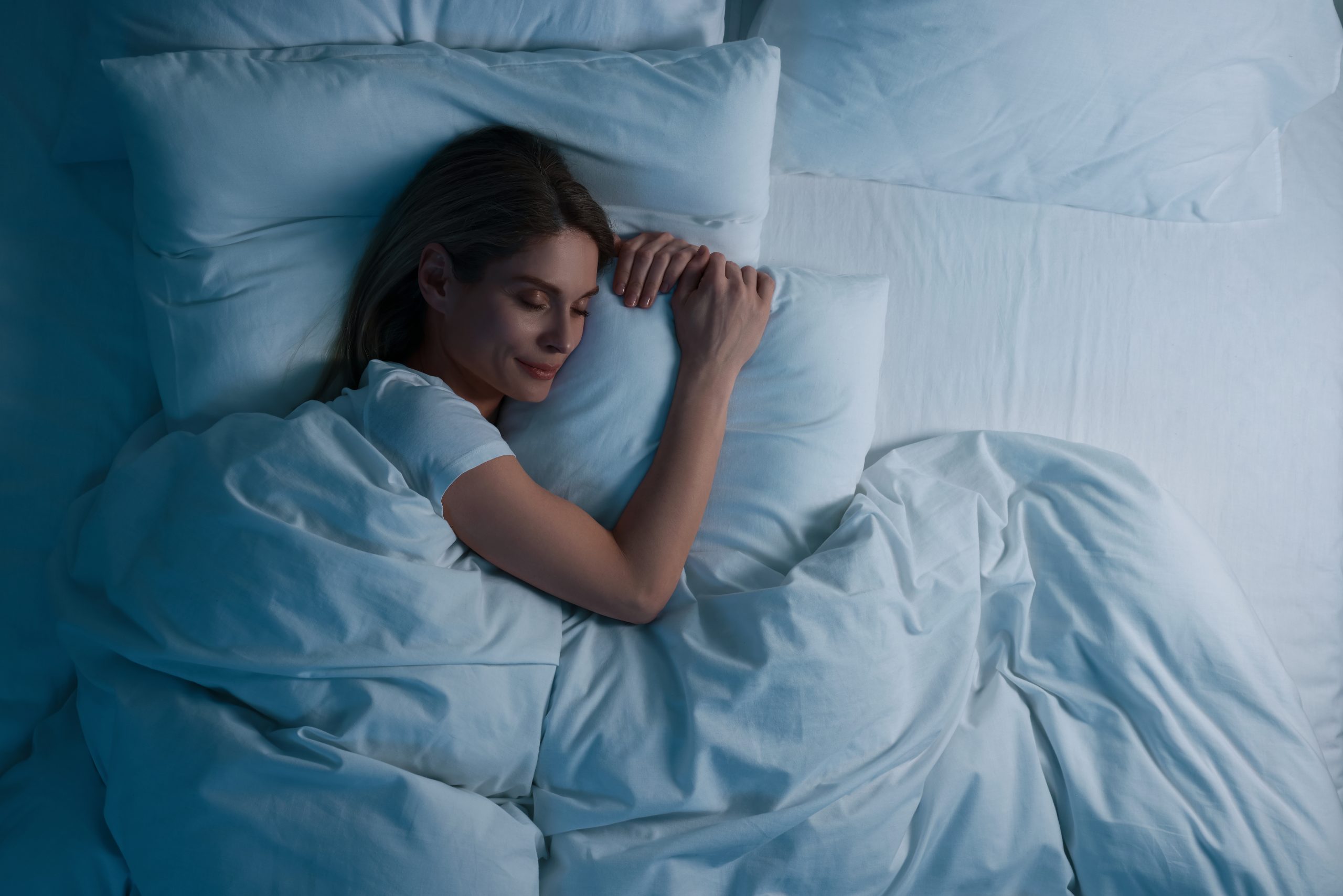 Frau schläft friedlich in einem Bett
